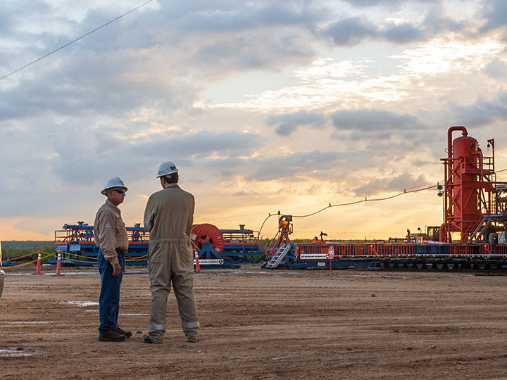 Two men talking near rig