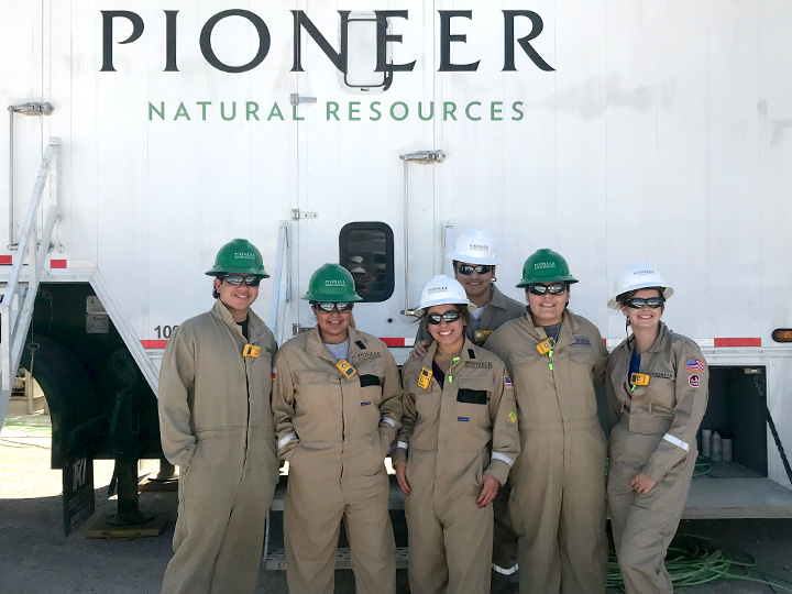 Some professionals in hard hats in front of a Pioneer product